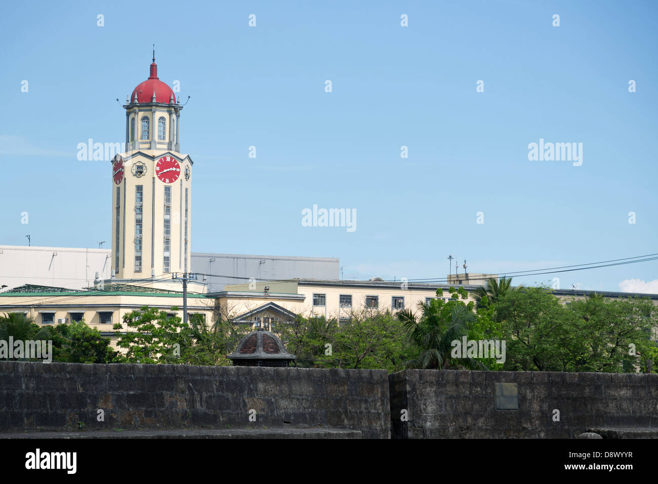 Vista su una torre orologio oltre le mura della città di Intramouros a Manila nelle Filippine Foto Stock