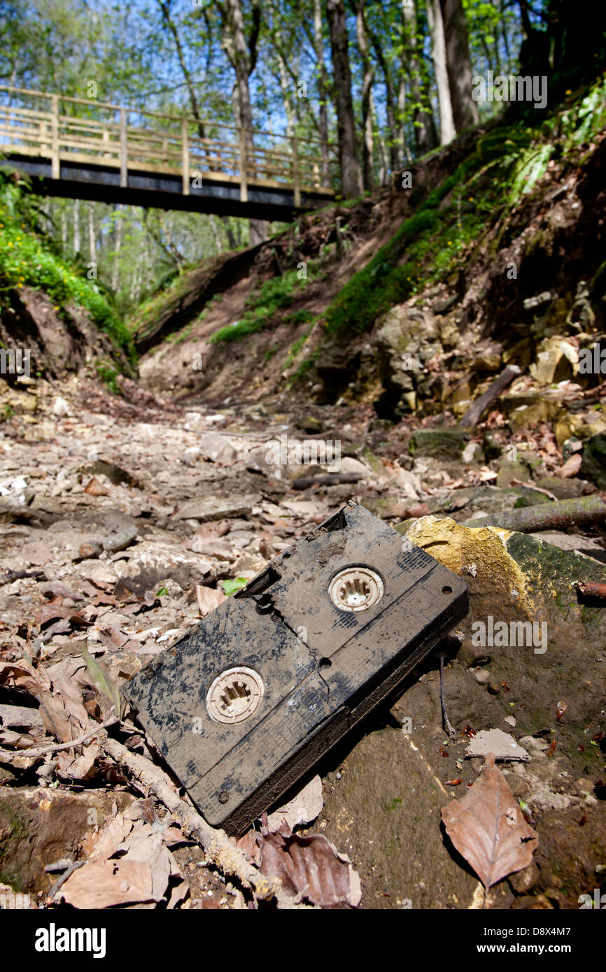 Immagine da Arcanum serie mostra danneggiato nastro VHS sat su riverbed secco sotto cavalcavia, aperto ai telespettatori di interpretazione. Foto Stock