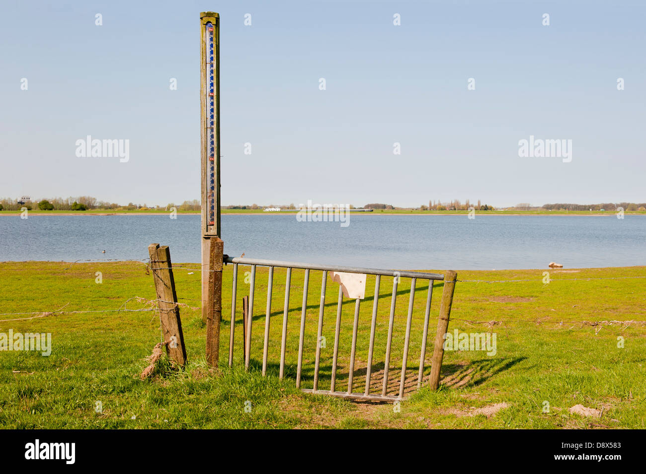 Cancello di ferro con la scala del livello dell acqua nelle pianure alluvionali del fiume IJssel a bassa marea, Paesi Bassi Foto Stock