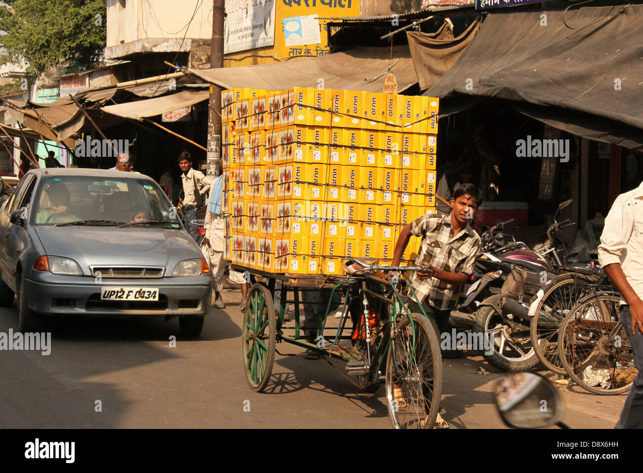 Ragazzo del ciclo di trazione Cargo rickshaw che trasportano le scatole di scarpe attraverso strade di Agra india Foto Stock