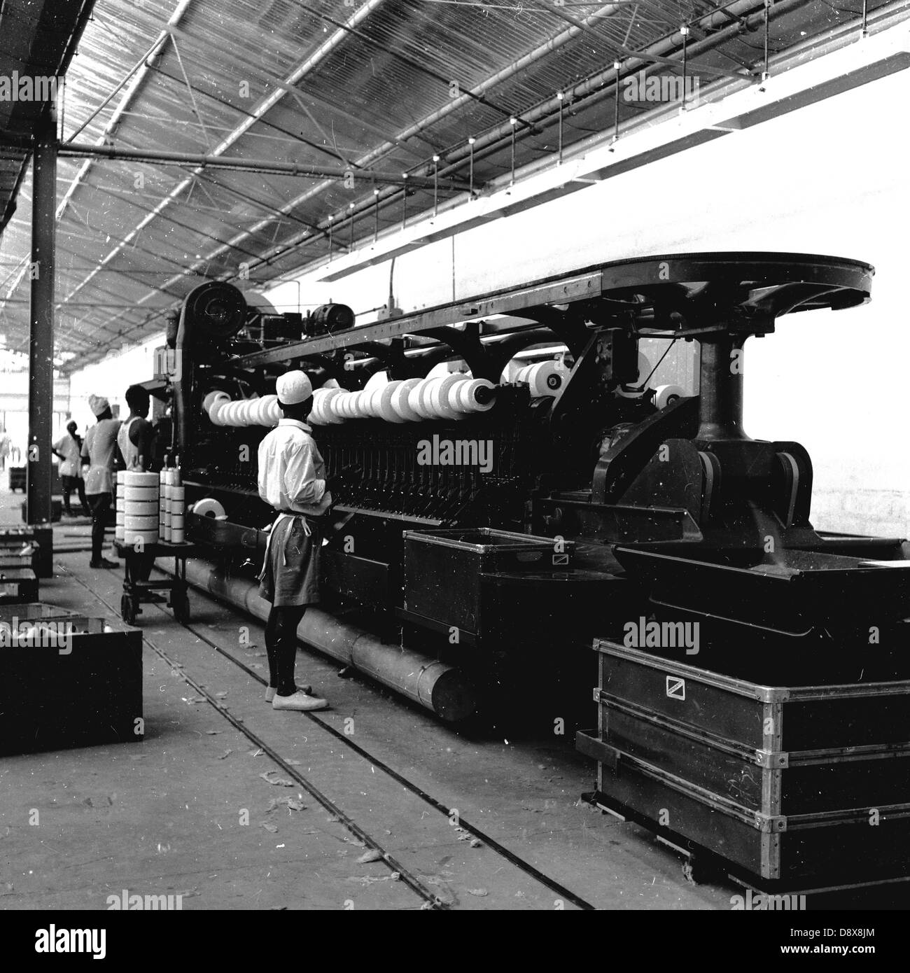 Anni '1950, storici, operatori maschili che lavorano in un grande telaio industriale di cotone o tessitura all'interno di una fabbrica, in India. Foto Stock Anni '1950, storici, operatori maschili che lavorano in un grande telaio industriale di cotone o tessitura all'interno di una fabbrica, in India. Foto Stock