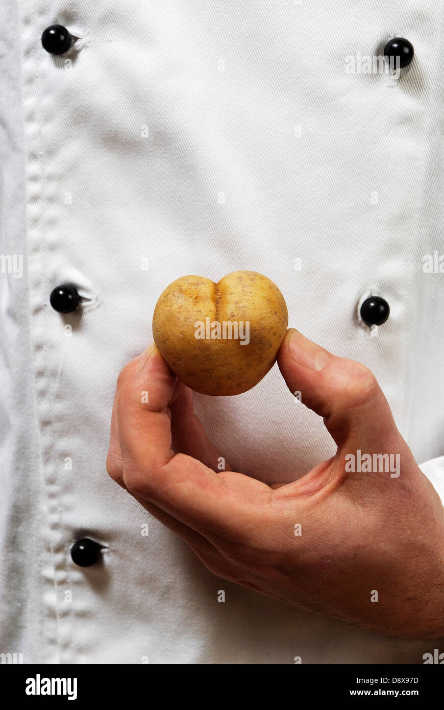 Un cuoco con un cuore di patata sagomata Foto Stock