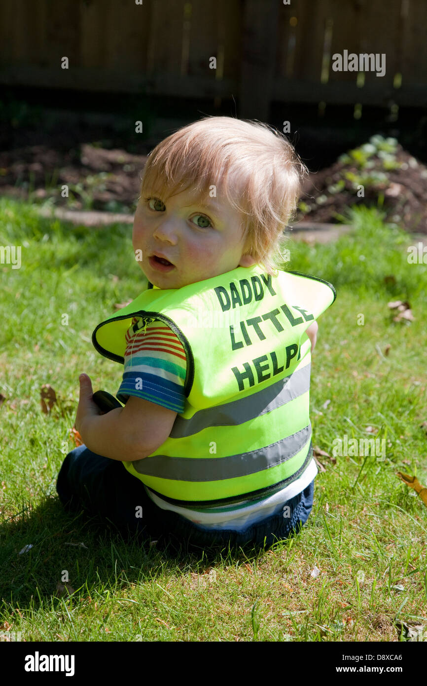Il Daddy's Little Helper: ragazzo giocando in giardino Foto Stock