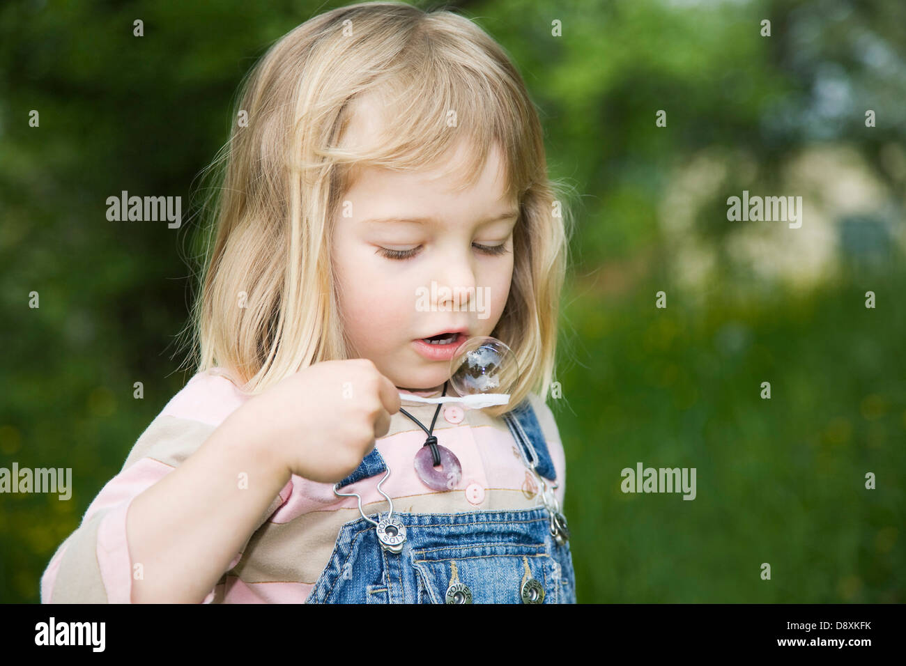 4 anno-vecchia ragazza il bilanciamento di una bolla di sapone Foto Stock