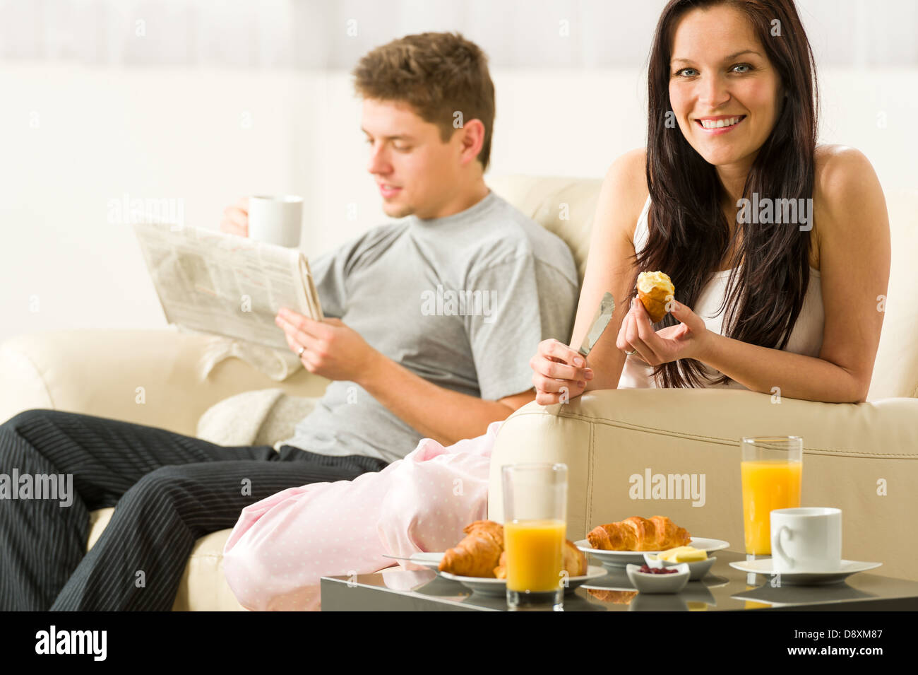 Coppia giovane spendere mattina tempo insieme a mangiare e la lettura Foto Stock