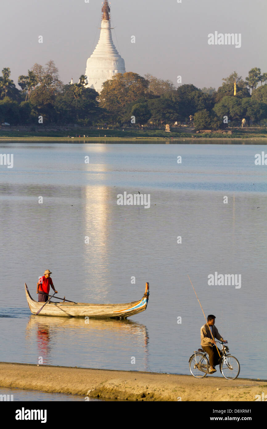 In bicicletta e in barca turistica racing sul lago Taungthaman, Myanmar Foto Stock