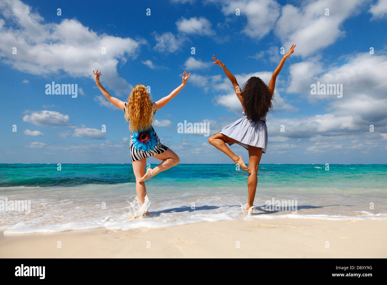 Due giovani donne con le mani alzate Foto Stock