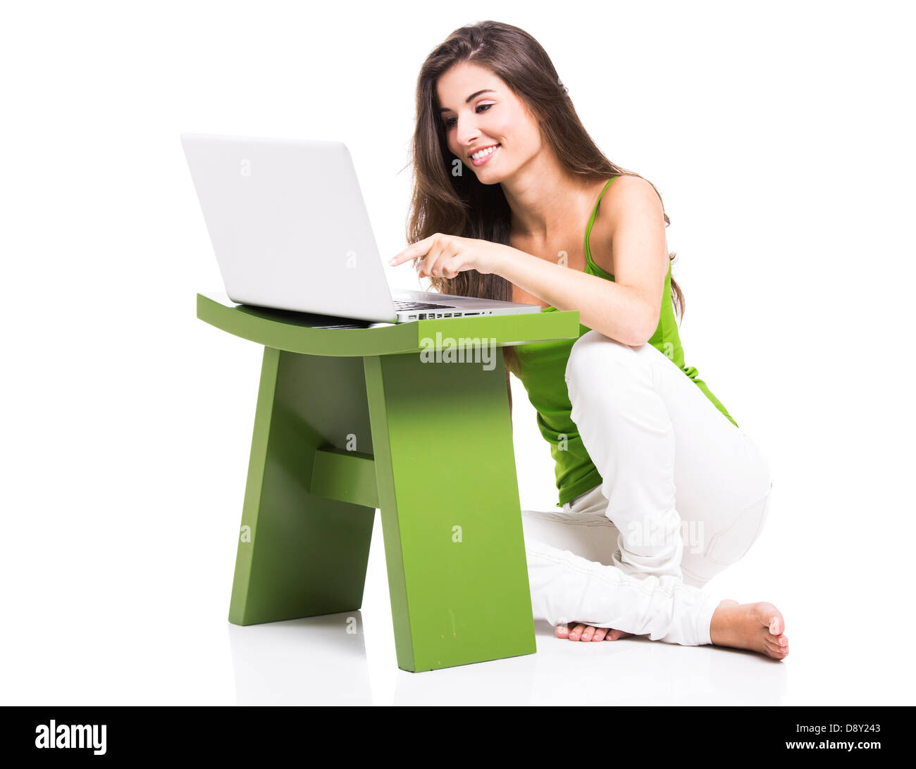 Bella donna seduta sul pavimento a lavorare con un computer portatile, isolate su un bianco Foto Stock