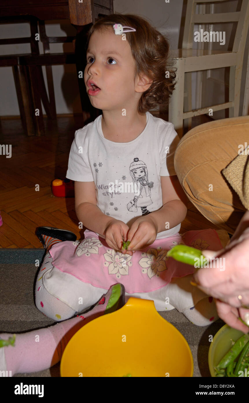 4 anno bambina di piselli da sgranare a casa Foto Stock