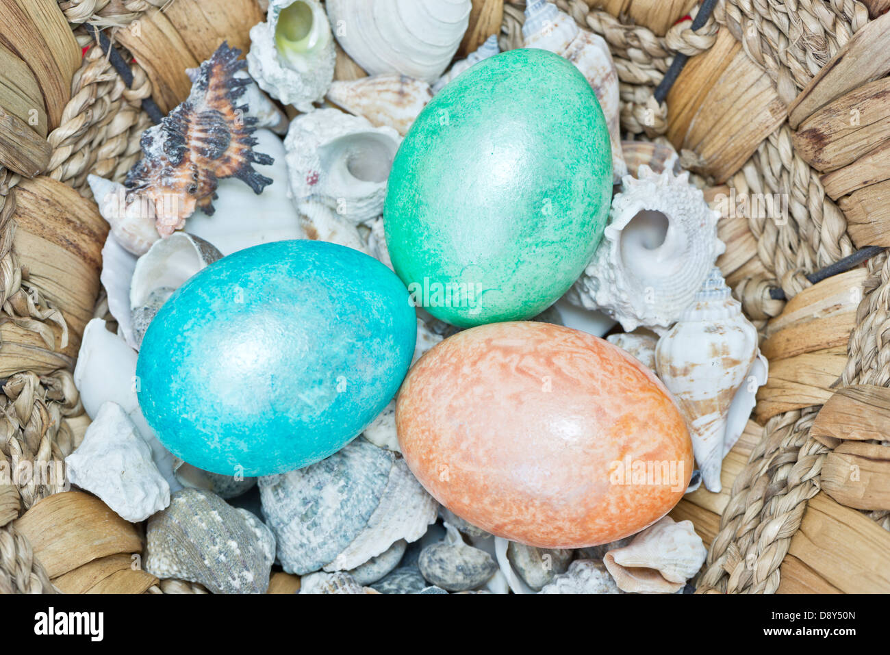Chiudere fino a tre colorfull pasqua uova con gusci in un cestello Foto Stock