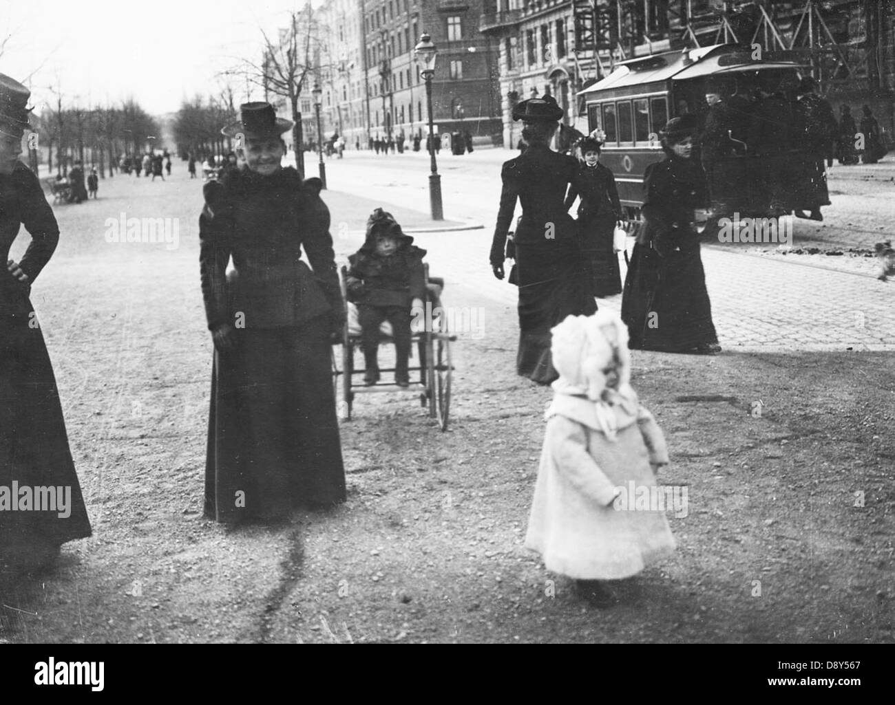 Una fotografia storica scattata circa 1890 di donne e bambini a Strandvagen a Stoccolma. Sullo sfondo, è visibile un tram trainato da cavalli, che mostra la vita urbana di Stoccolma durante la fine del XIX secolo. Foto Stock