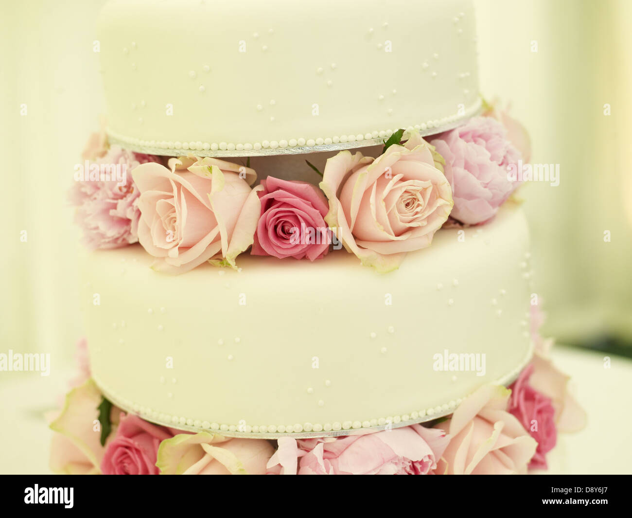 Un delicato tre-tier torta decorata con rose. Foto Stock