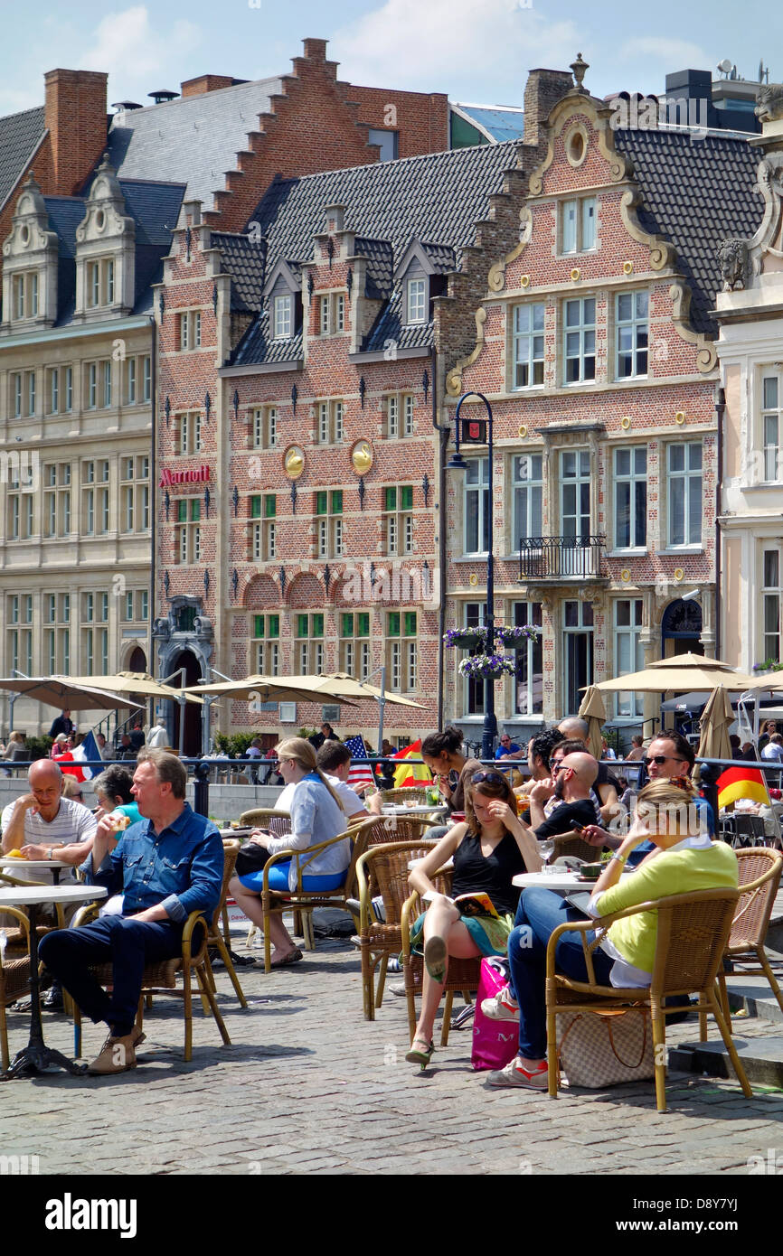 I turisti alla caffetteria sul marciapiede sul Graslei / Erba Lane in estate a Ghent, Belgio Foto Stock