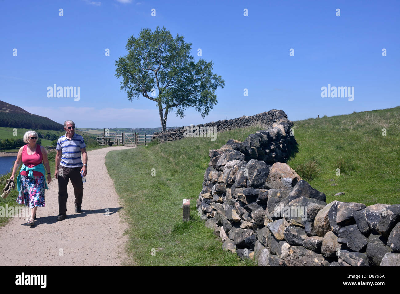 Un anziano uomo e donna che cammina sul percorso intorno colomba serbatoio di pietra, greenfield, oldham, Regno Unito Foto Stock