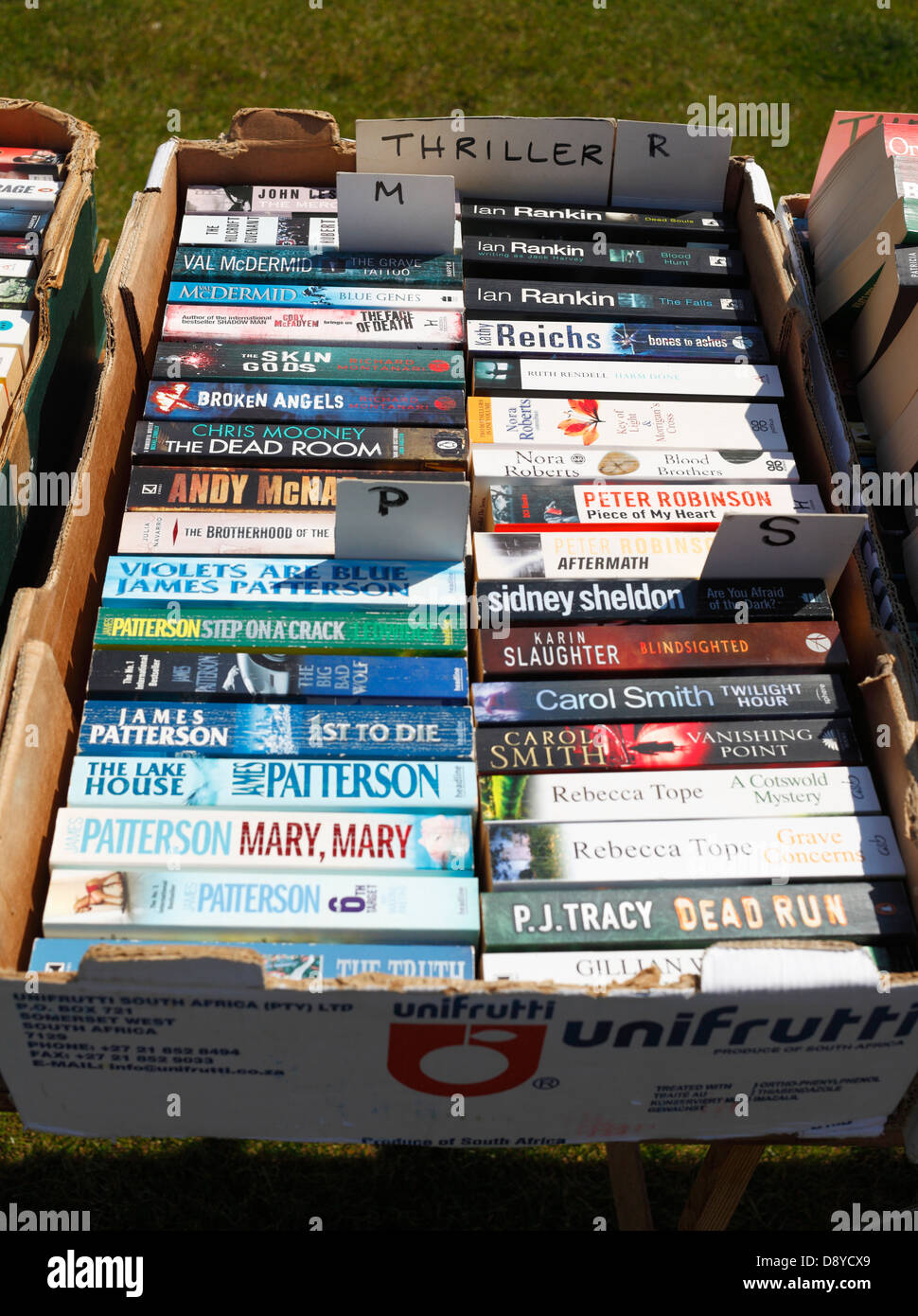 Scatola di seconda mano paperback thriller al bagagliaio della vettura in vendita. Foto Stock