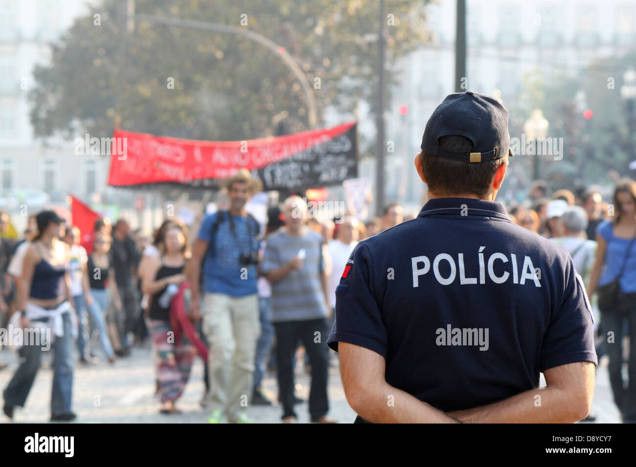 Strada popolare manifestazione con il funzionario di polizia a guardare Foto Stock