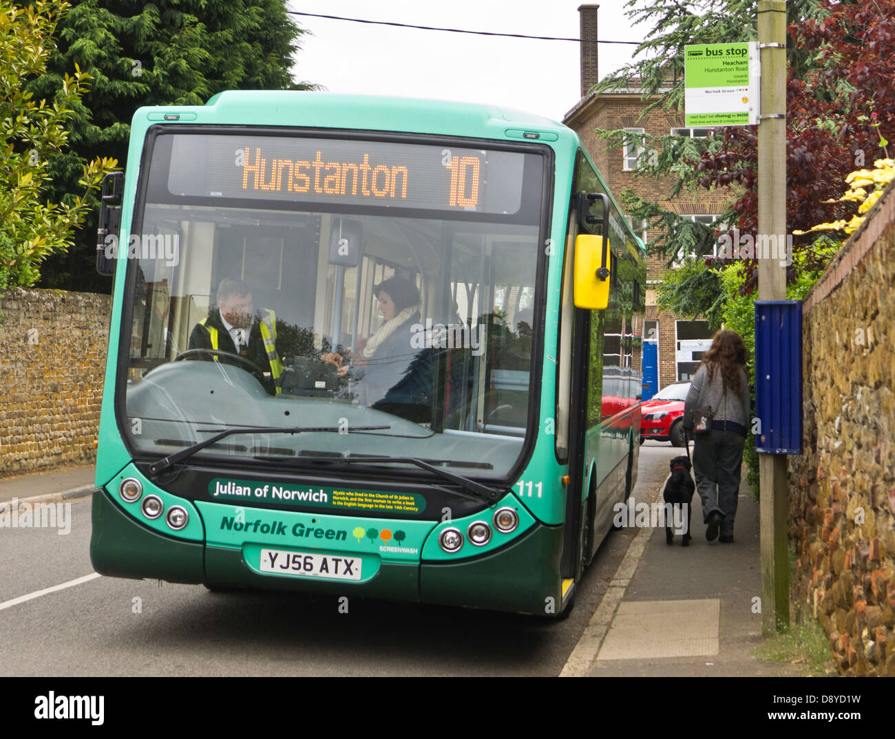 Donna di salire a bordo di un bus rurale in Heacham, Norfolk e pagando il conducente la sua tariffa. Foto Stock
