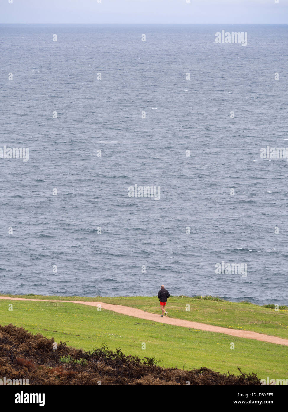 L'uomo jogging da soli accanto all'oceano Foto Stock