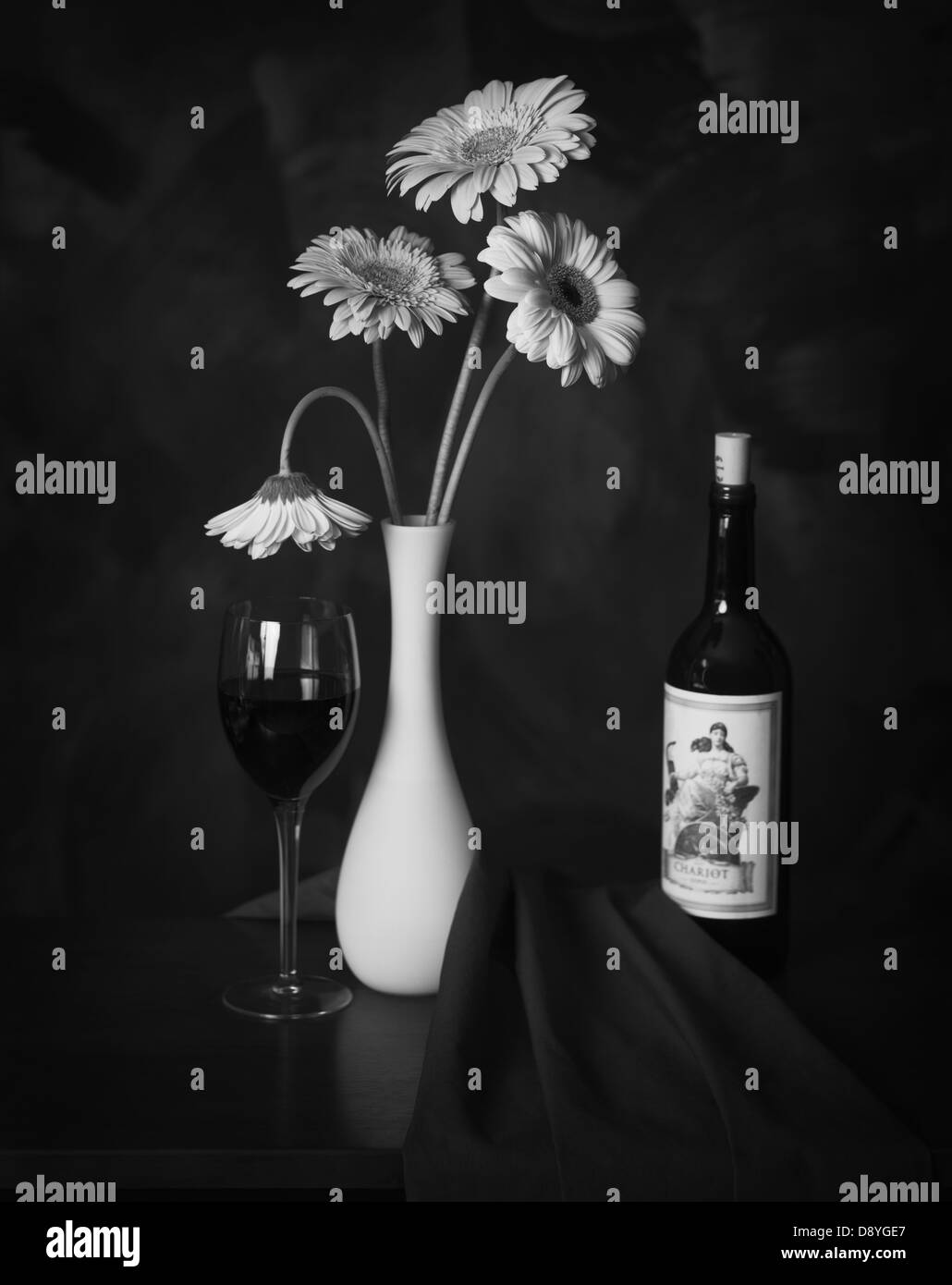Ancora in vita con una bottiglia di vino e un bicchiere di vino e un vaso bianco regge quattro margherite Gerbera Foto Stock