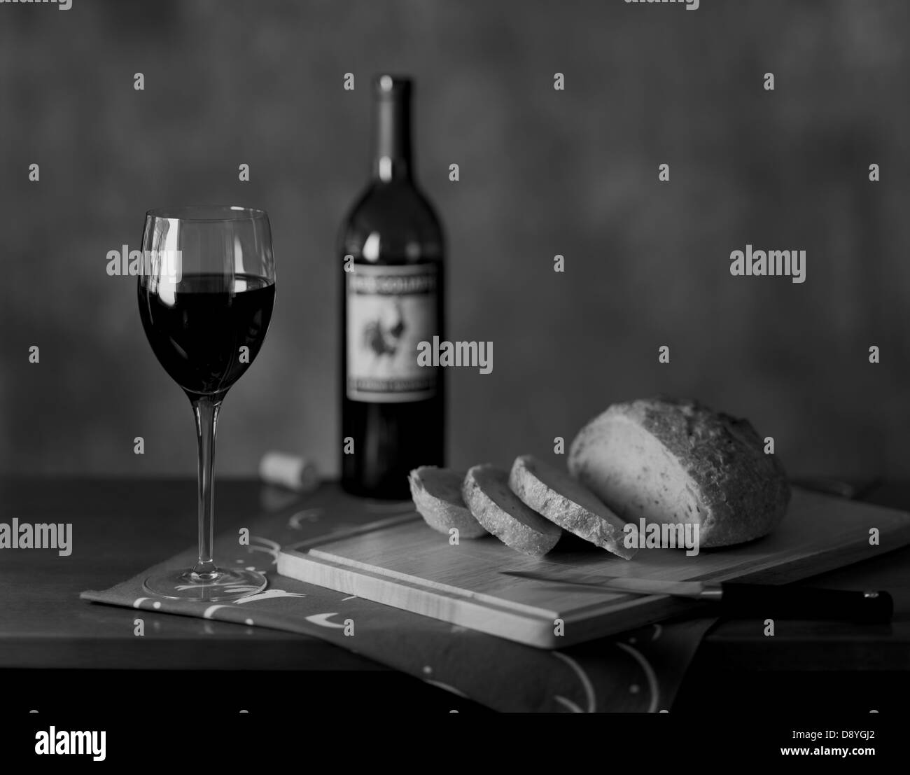 Ancora una vita che mostra una bottiglia di vino e un bicchiere di vino e fette di pane fresco. Foto Stock