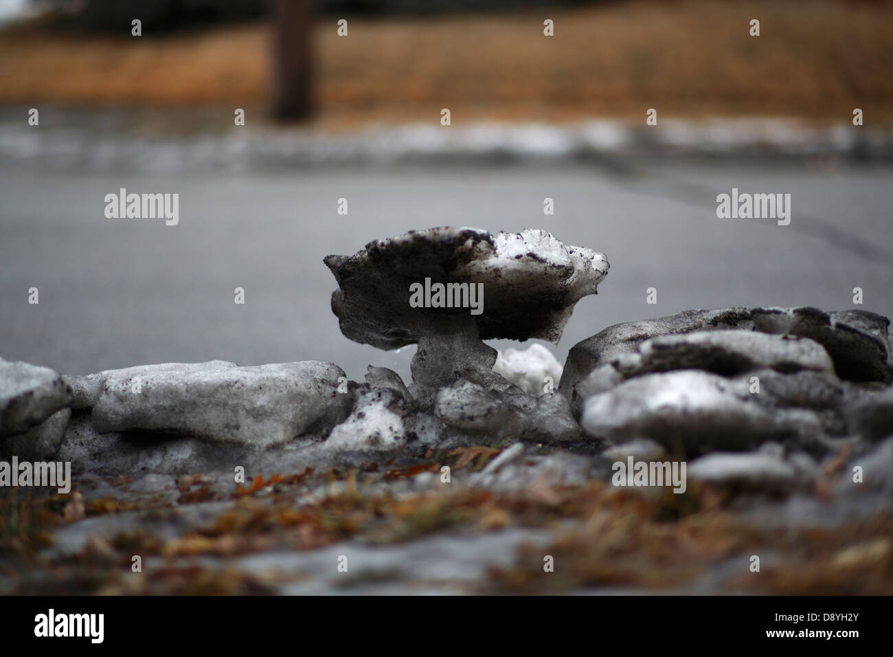Neve sporca accanto alla strada, fuso in boulder-come le forme. Foto Stock