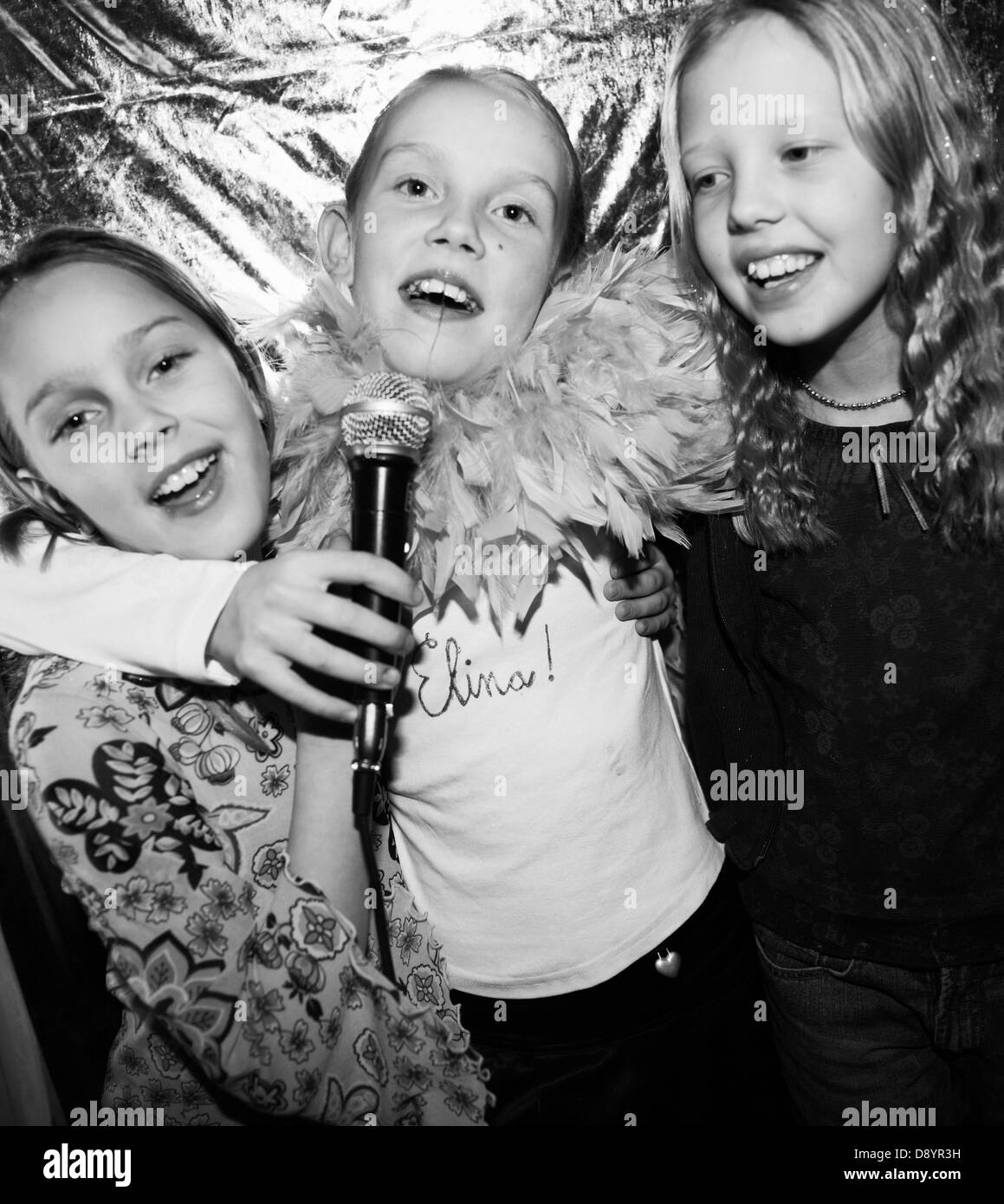 Le tre ragazze a cantare in un microfono. Foto Stock