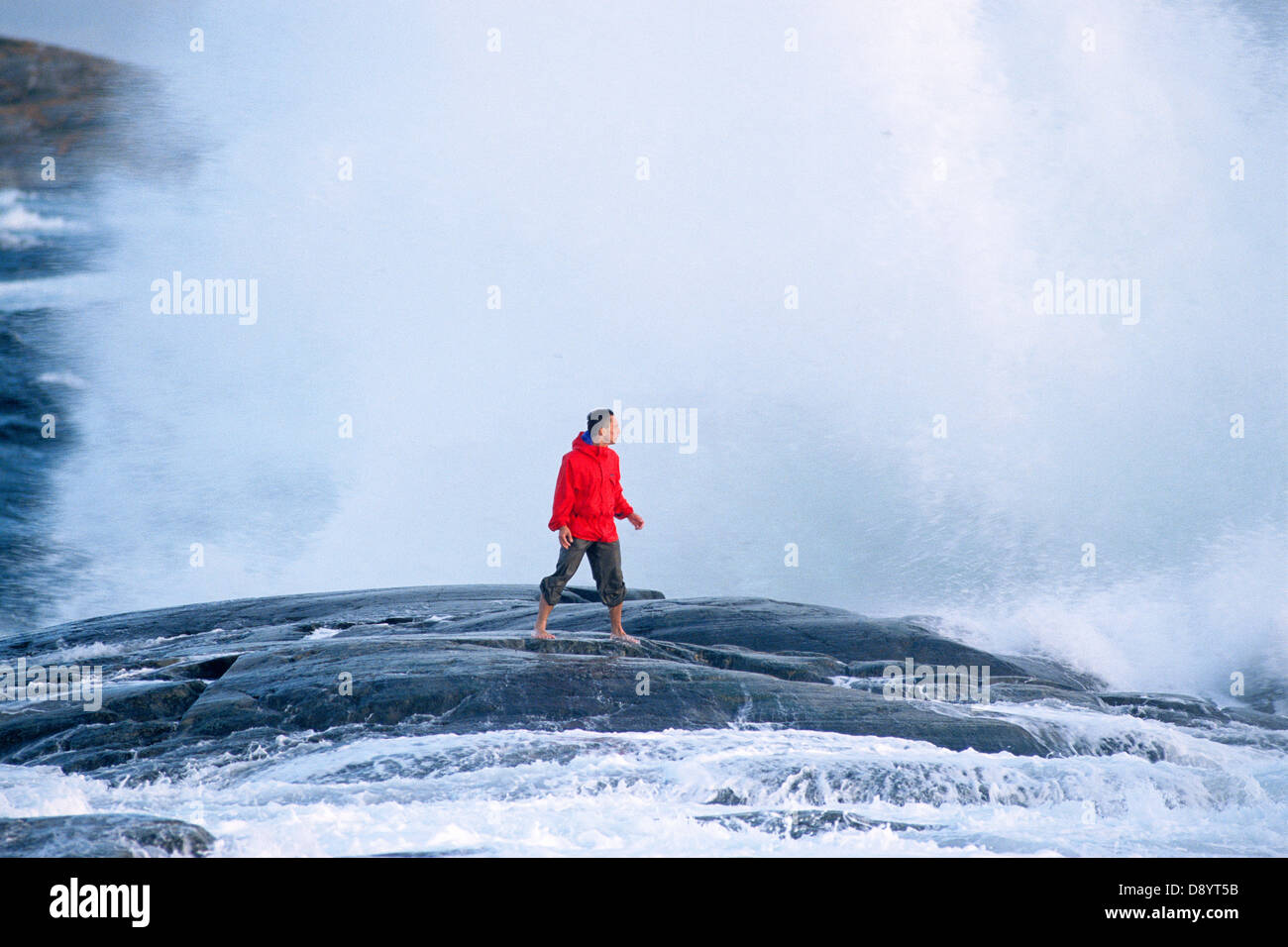 Un uomo su scogliere durante le tempeste. Foto Stock