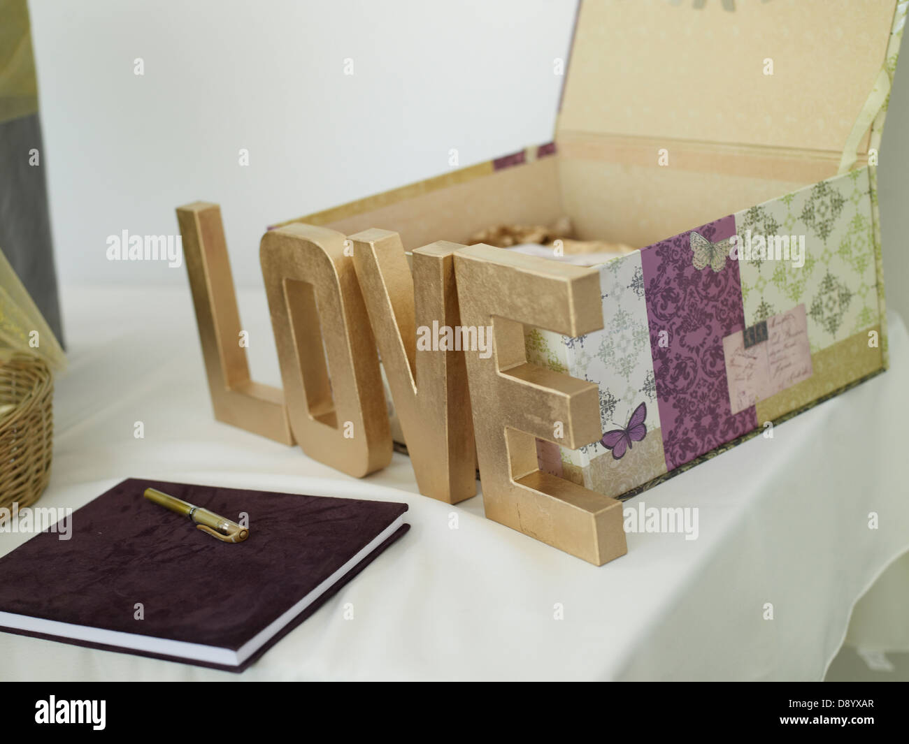 Una disposizione di decorazioni per matrimoni, compresa una penna, un libro, una scatola e un cartello che dice che "l'amore". Foto Stock