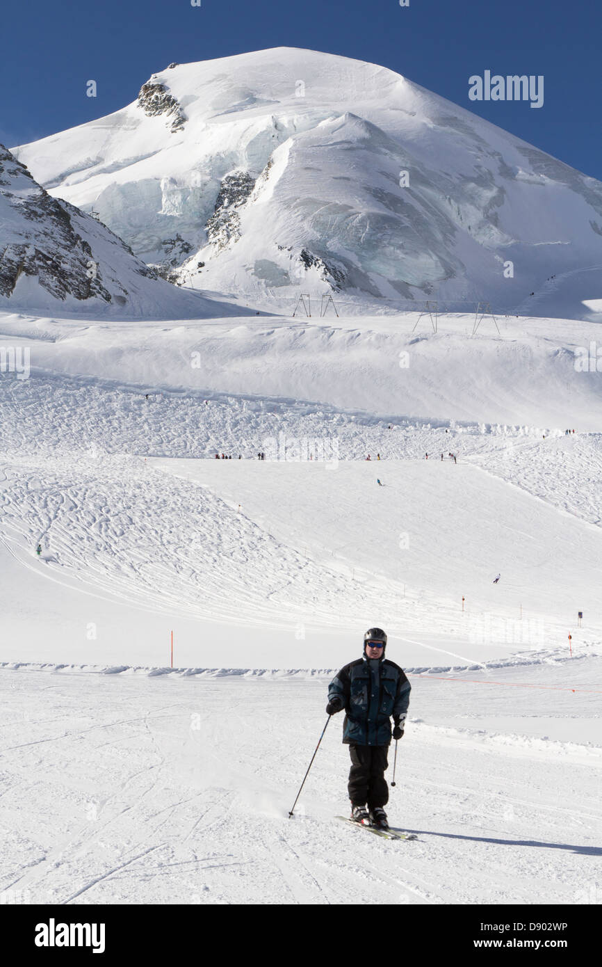 Tassa ghiacciaio, Saas fee, Vallese, Svizzera. Uno sciatore su una pista da sci sul ghiacciaio durante una giornata invernale. Foto Stock