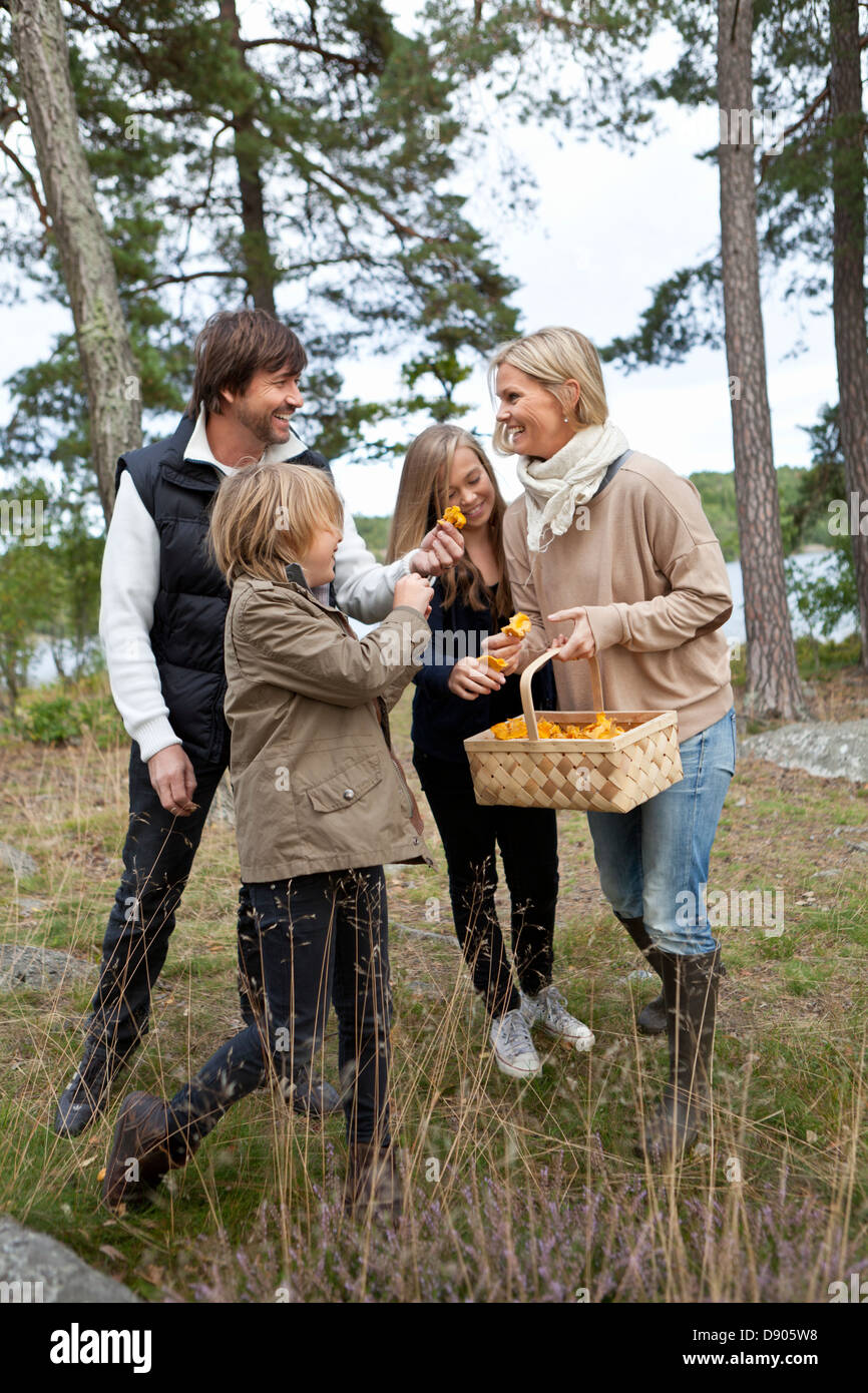 Famiglia con due bambini raccolta di funghi Foto Stock
