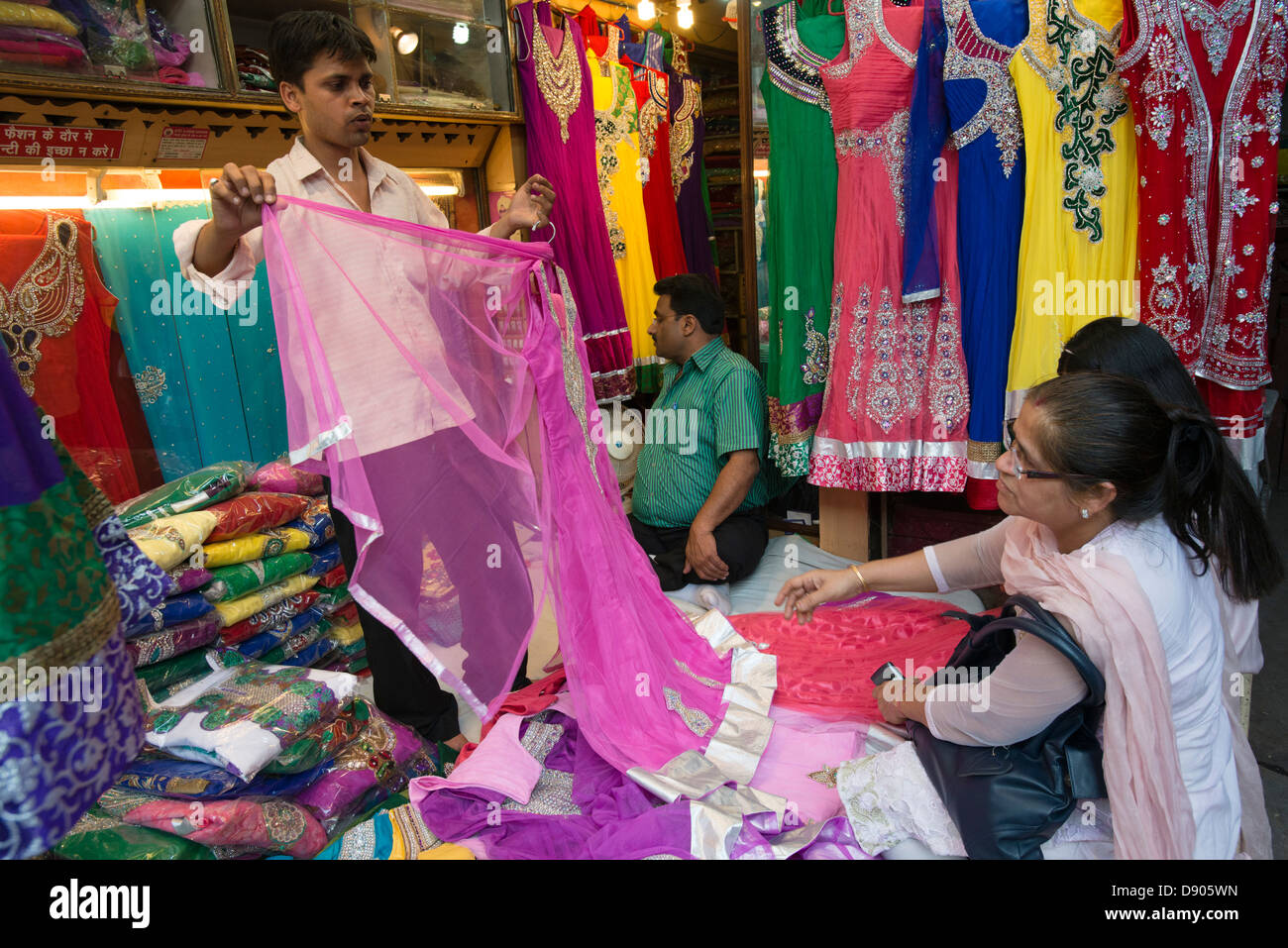 Il trasportatore si mette in mostra la sua merce ai clienti in un mercato di Vecchia Delhi, India Foto Stock