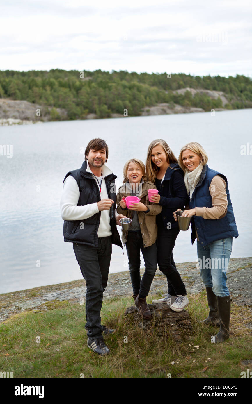 Famiglia con due bambini in piedi dal lago Foto Stock