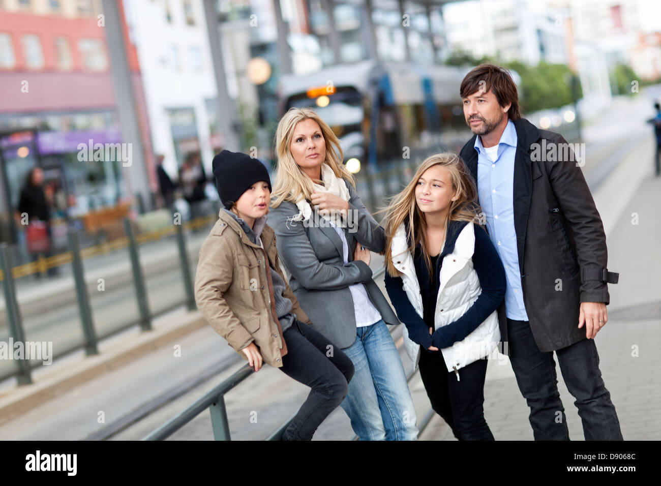 Famiglia con due bambini in attesa di tram Foto Stock
