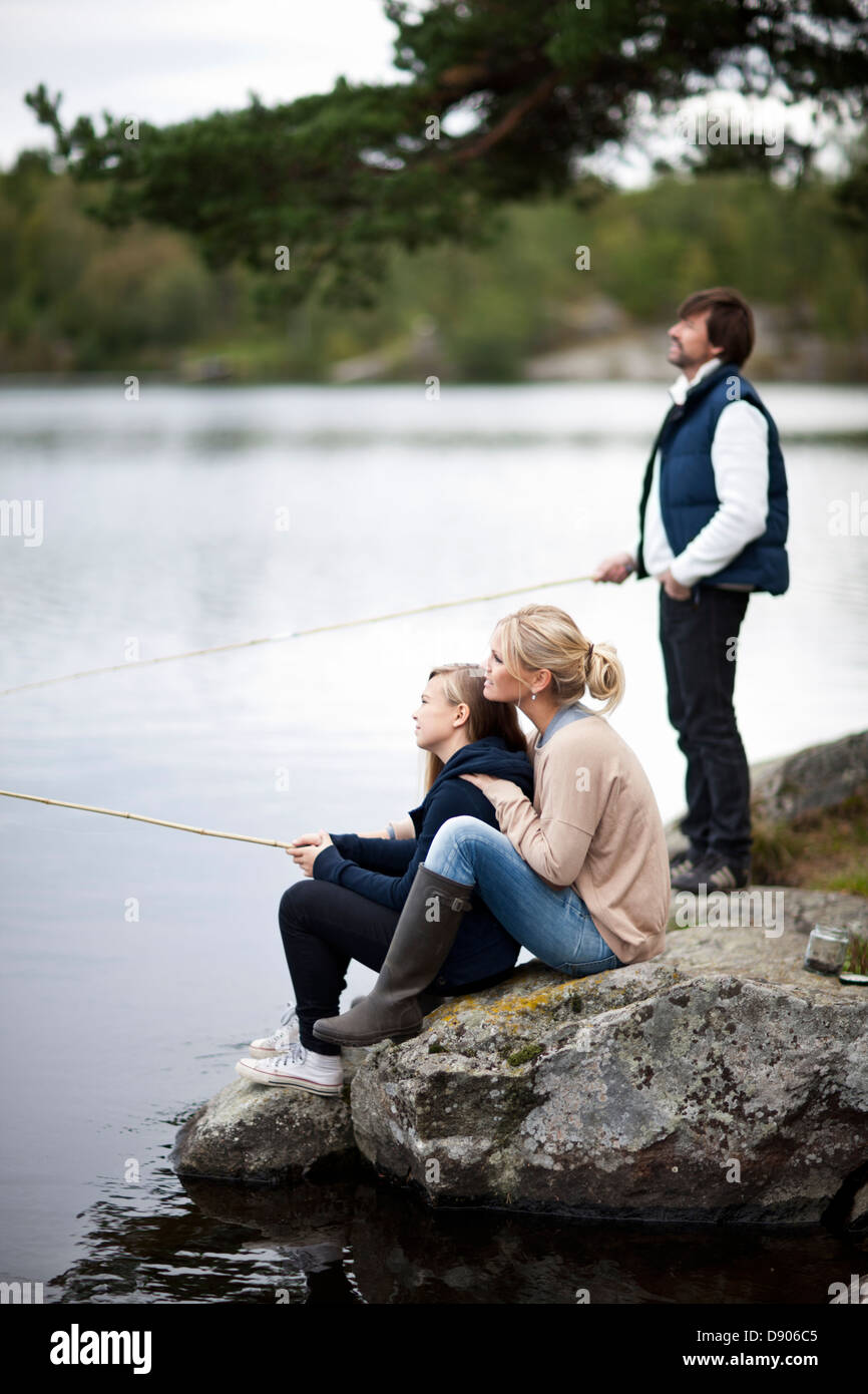 Famiglia con la figlia la pesca sul lago Foto Stock