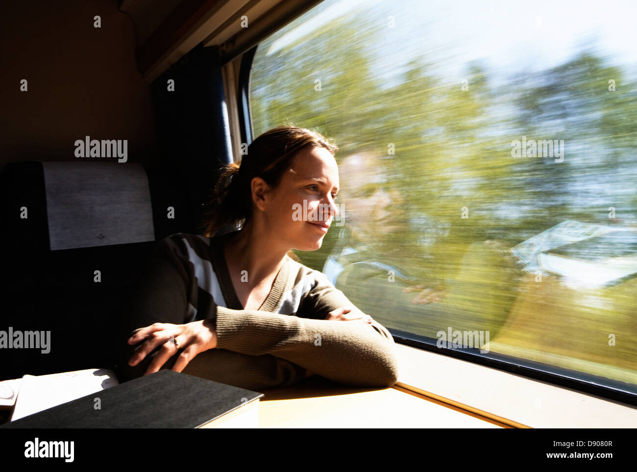 Donna che guarda fuori dalla finestra da un treno. Foto Stock
