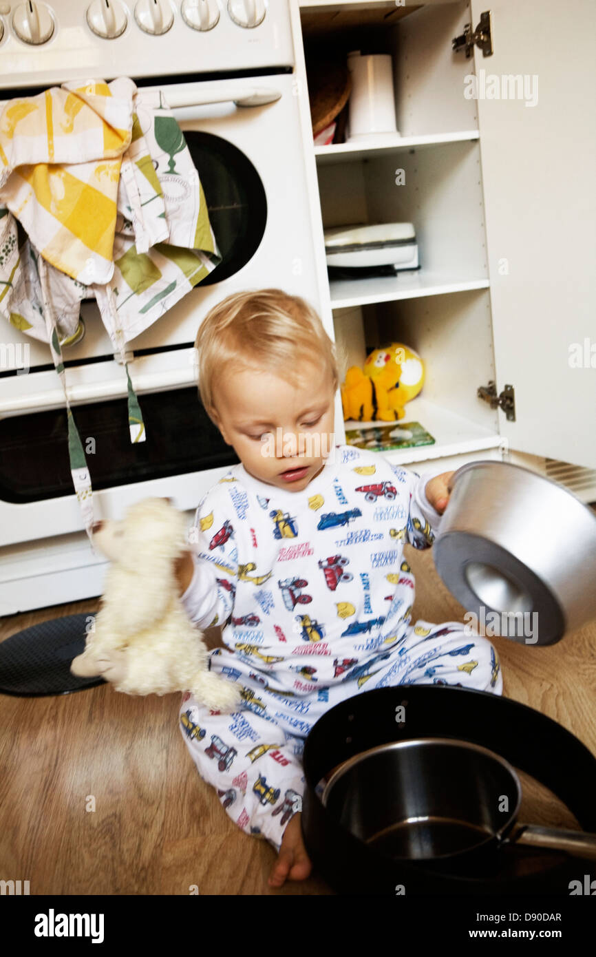 Un ragazzo giocando con teglie. Foto Stock