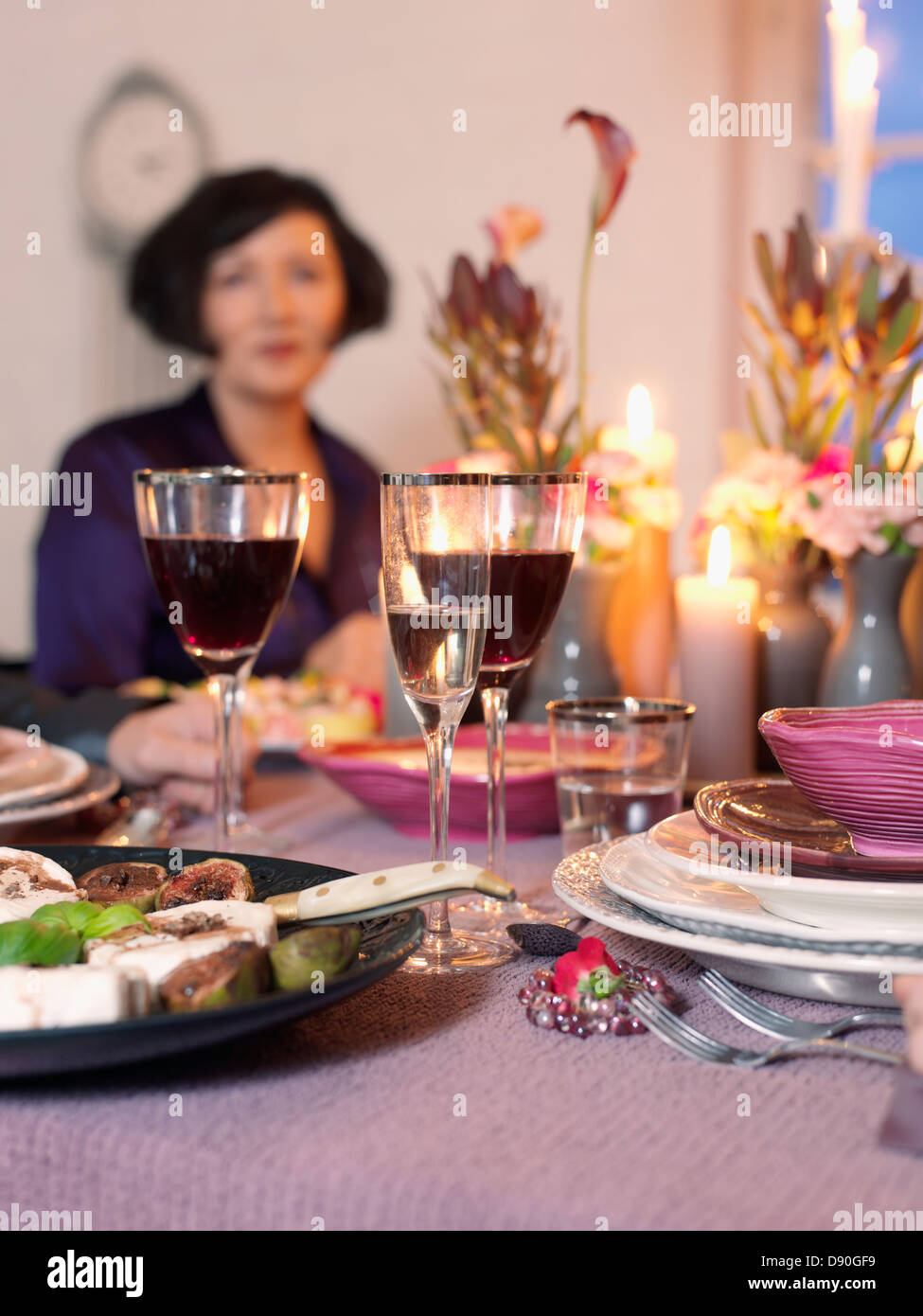 Donna seduta in elegante tavolo da pranzo Foto Stock