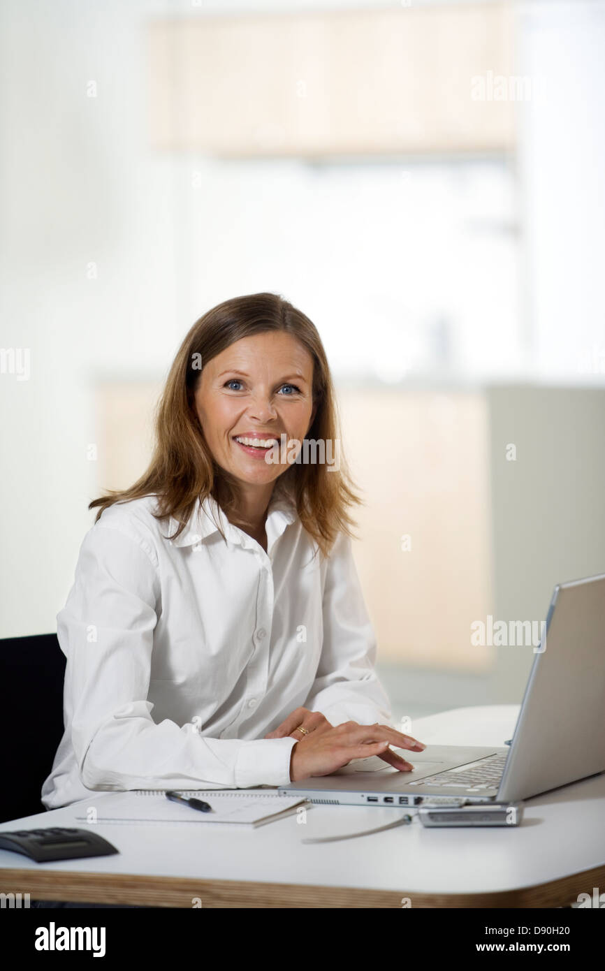 Una donna che lavora in un ufficio. Foto Stock