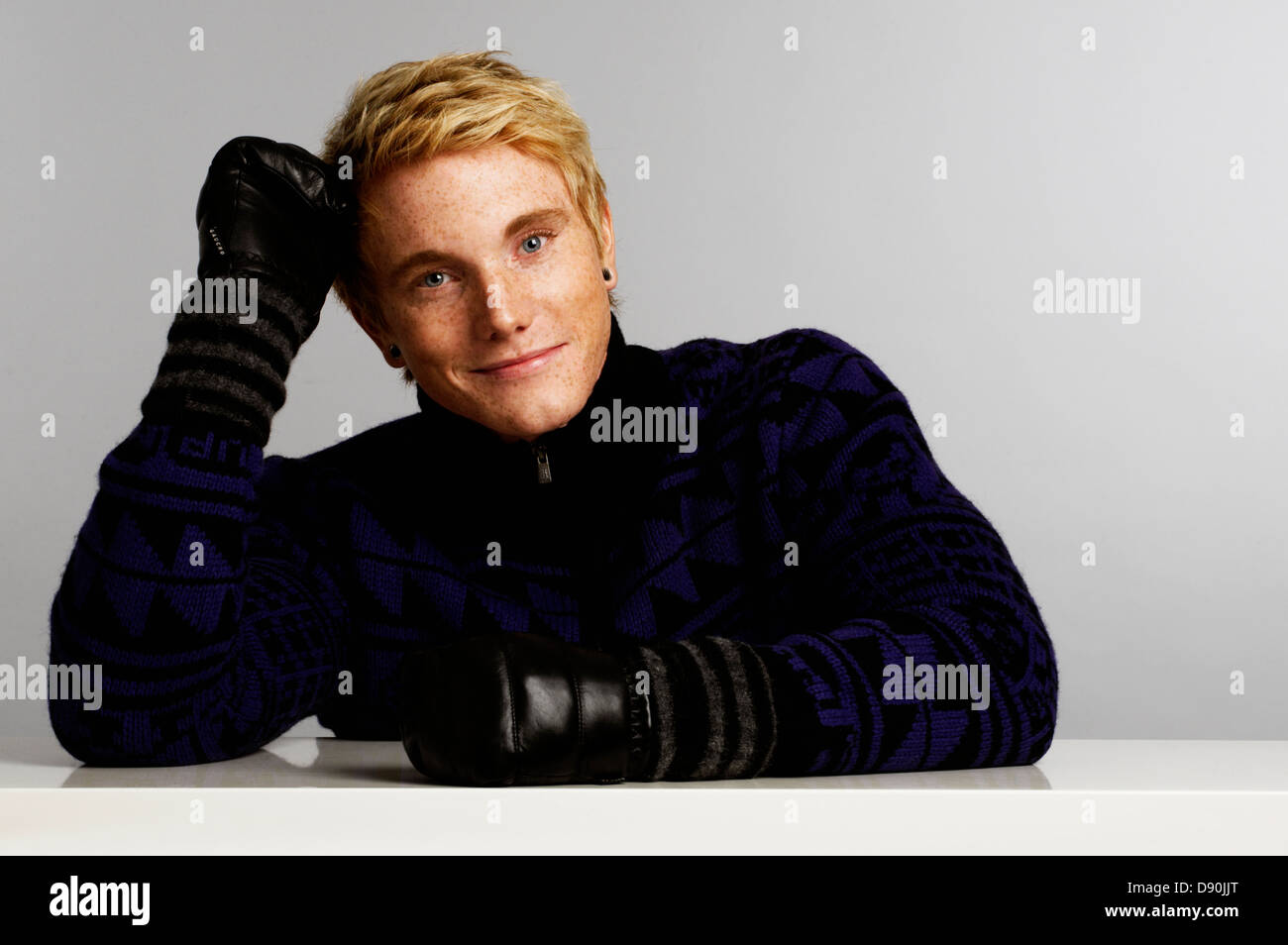 Giovane uomo appoggiata e sorridente Foto Stock