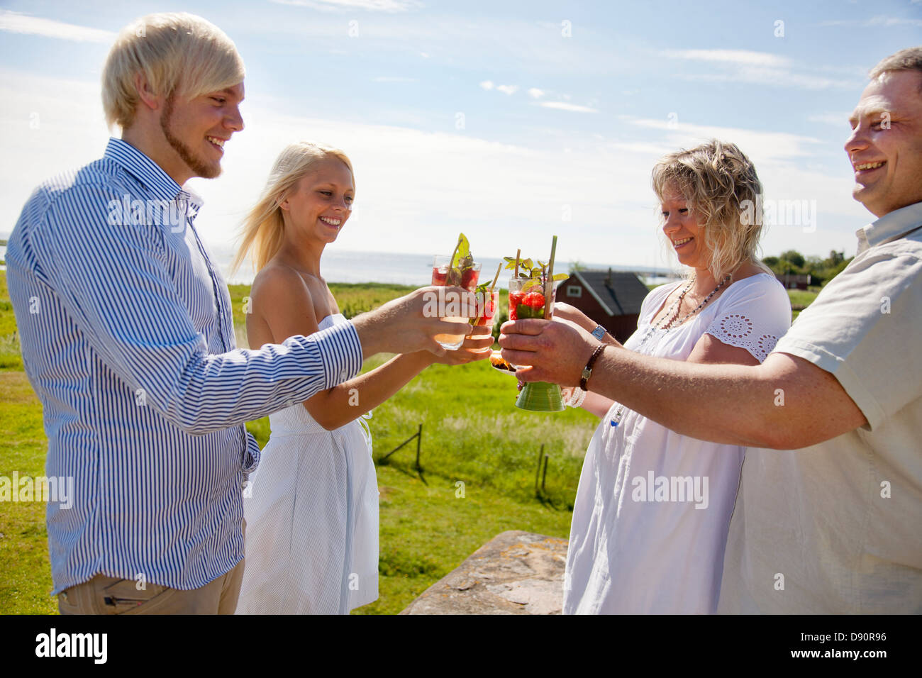 Coppie drink di tostatura a costa, sorridente Foto Stock