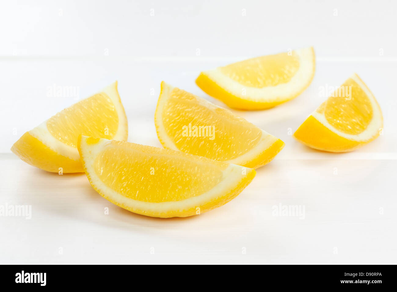 Spicchi di limone su sfondo bianco - spicchi di limone o fette su uno sfondo bianco con le ombre morbide. Foto Stock