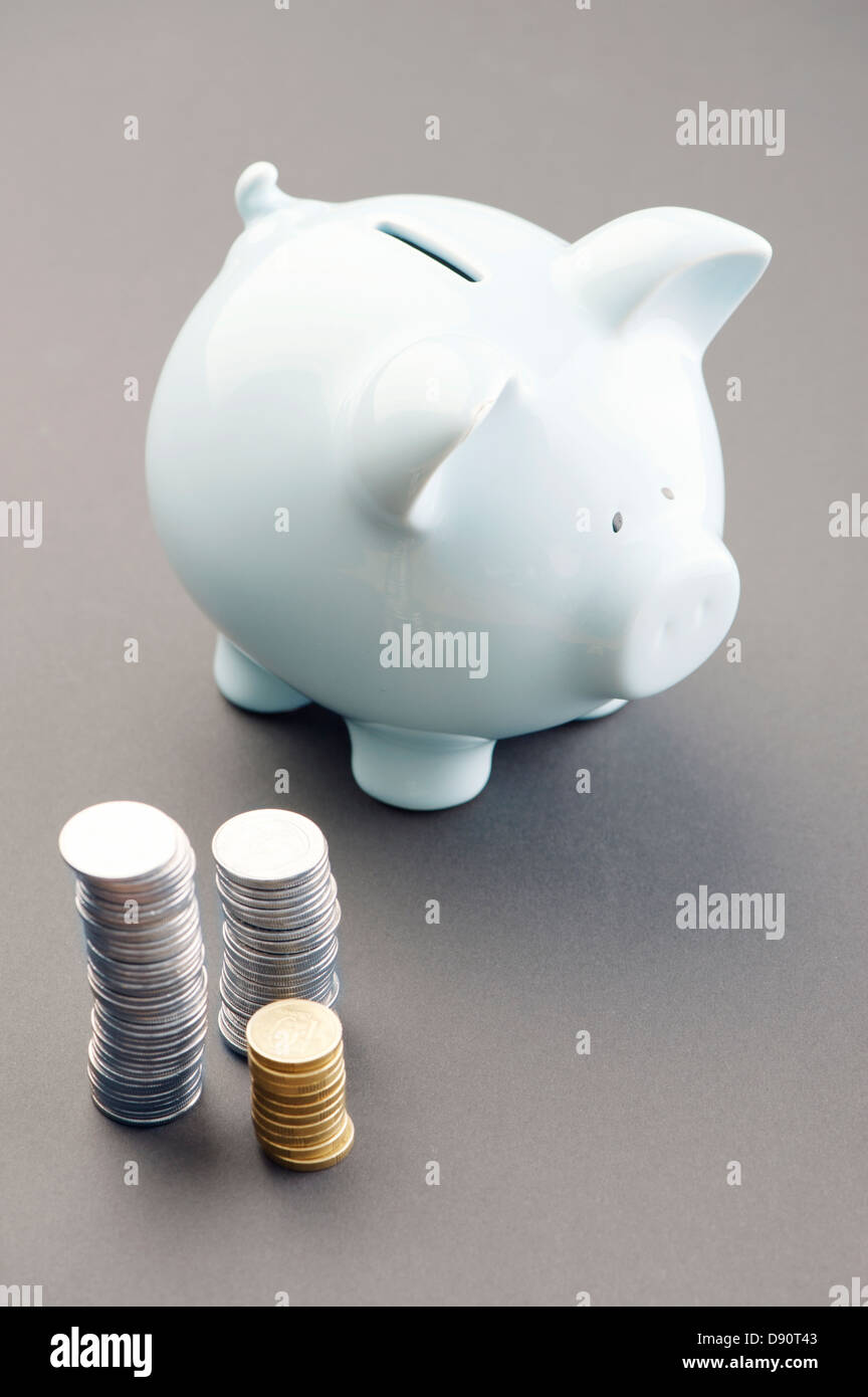 Monete e una casella di risparmio Foto Stock