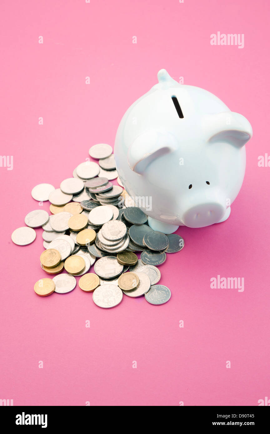 Monete e una casella di risparmio Foto Stock