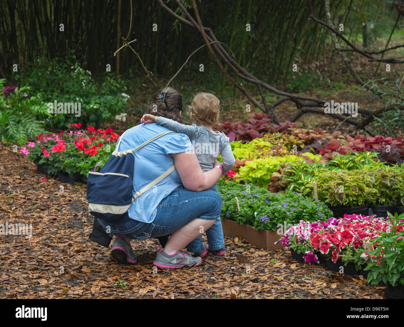 Madre mostra il suo bambino di piante fiorite durante Kanapaha Botanical Gardens Festival di Primavera si trova a Gainesville Florida. Foto Stock
