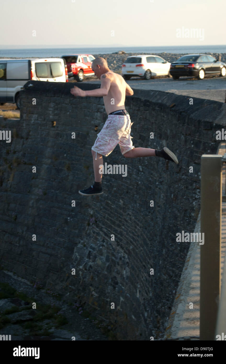 Lads saltando dalla penna Yr Angor / Tan Y Bwlch ponte nel fiume Ystwyth al punto si incontra Aberystwyth Harbour. Foto Stock