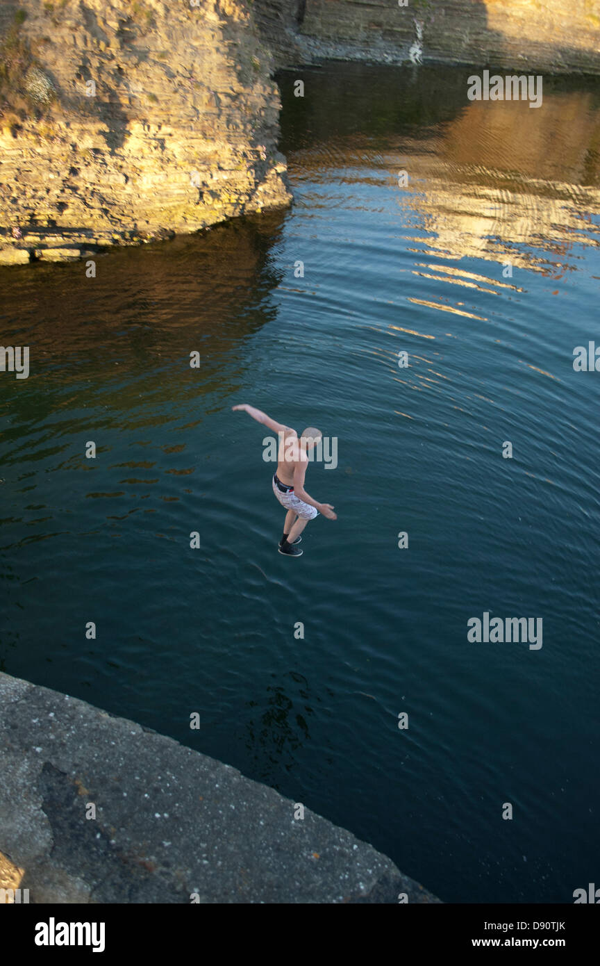 Lads saltando dalla penna Yr Angor / Tan Y Bwlch ponte nel fiume Ystwyth al punto si incontra Aberystwyth Harbour. Foto Stock