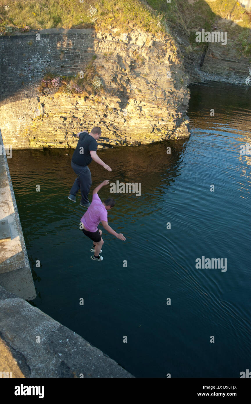 Lads saltando dalla penna Yr Angor / Tan Y Bwlch ponte nel fiume Ystwyth al punto si incontra Aberystwyth Harbour. Foto Stock