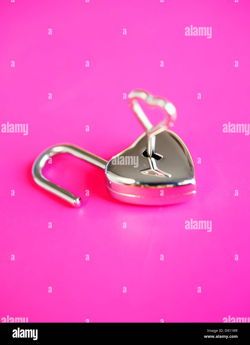 Close-up di piccoli a forma di cuore ad lucchetto sullo sfondo rosa Foto Stock