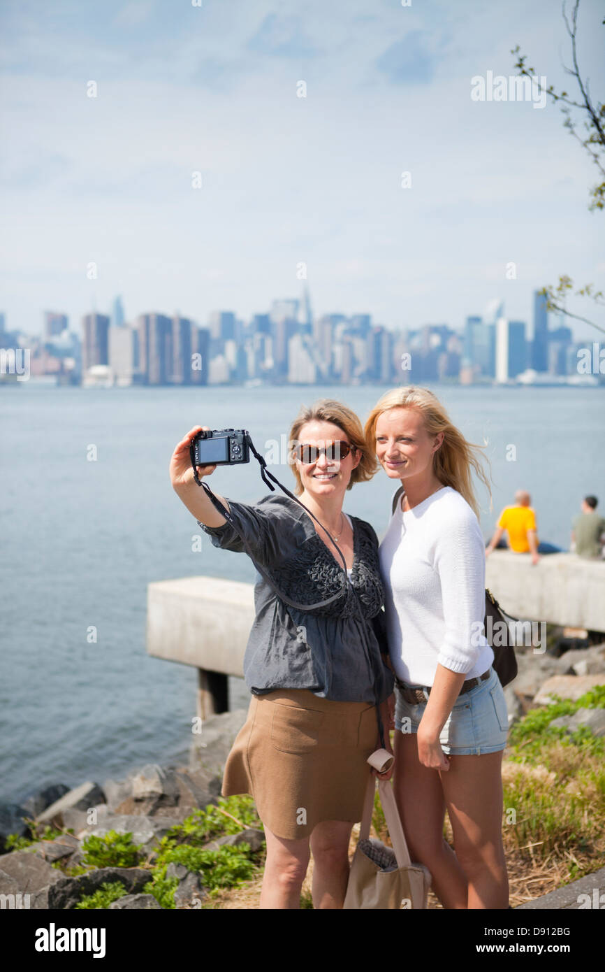 Madre e figlia di fotografare sé con skyline di New York in background Foto Stock