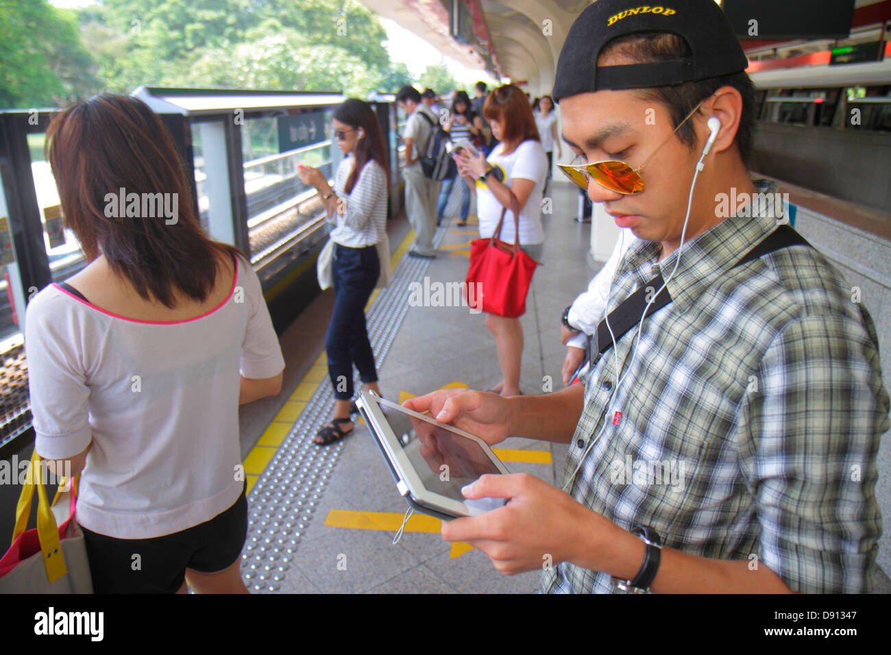 Singapore SMRT, East West Green Line, Stazione Tanah Merah, trasporto rapido di massa, uomo asiatico uomo maschio, passeggeri passeggeri motociclisti, pilota, piattaforma, uso, A Foto Stock